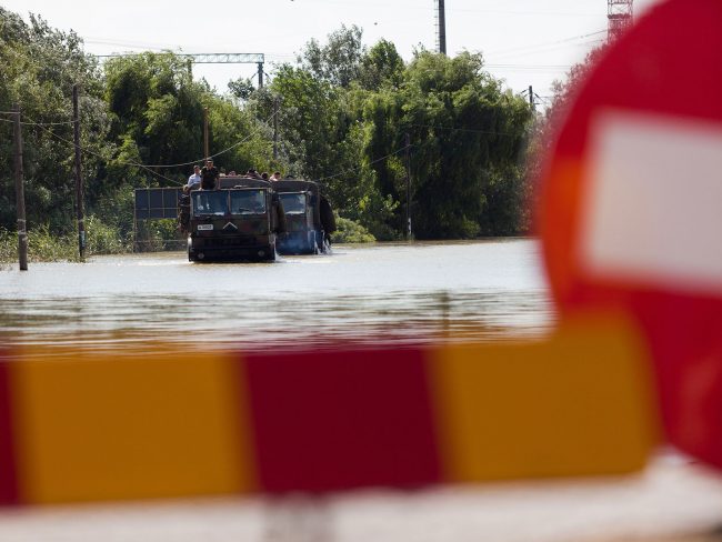 Army trucks are crossing a flooded closed road în Șendreni, Romania on July 3rd, 2010.