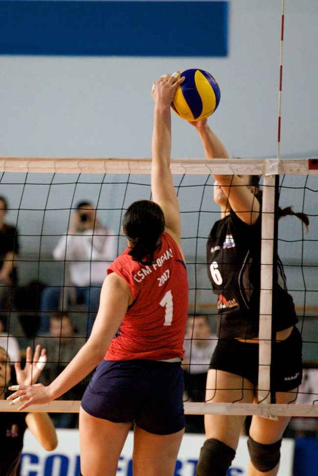 Voleyball players are fighting over the ball in a game played in Galați, Romania on February 20th, 2010.