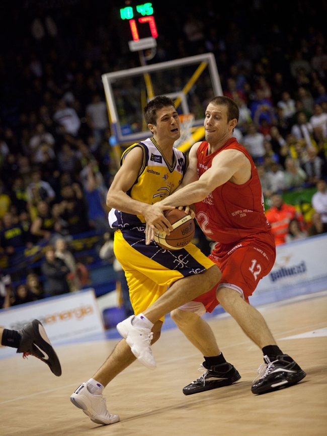 Two basketball players are fighting for the ball in a match between Armani Jeans Milano (IT) and Sutor Montegranaro (IT) in Porto San Giorgio, Italy on November 28th, 2010.