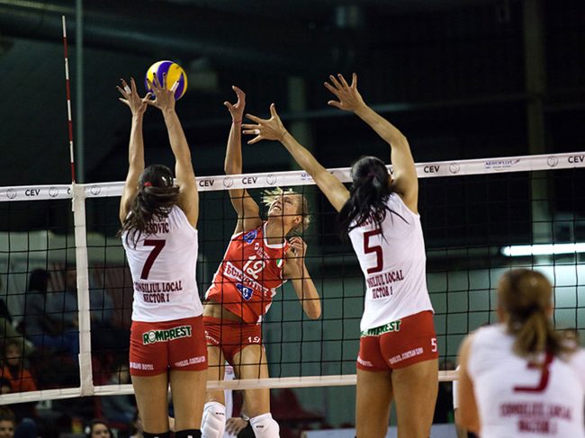 Volley players are playing in a CEV Cup match between Scavolini Pesaro (IT) and Dinamo București (RO) in Pesaro, Italy on December 8th, 2010.